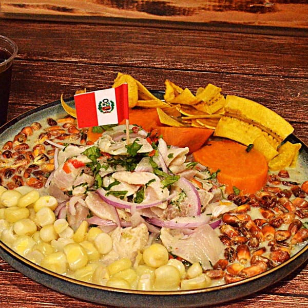 Peruvian ceviche with fish, red onions, corn, sweet potato, plantain chips, and a Peruvian flag.